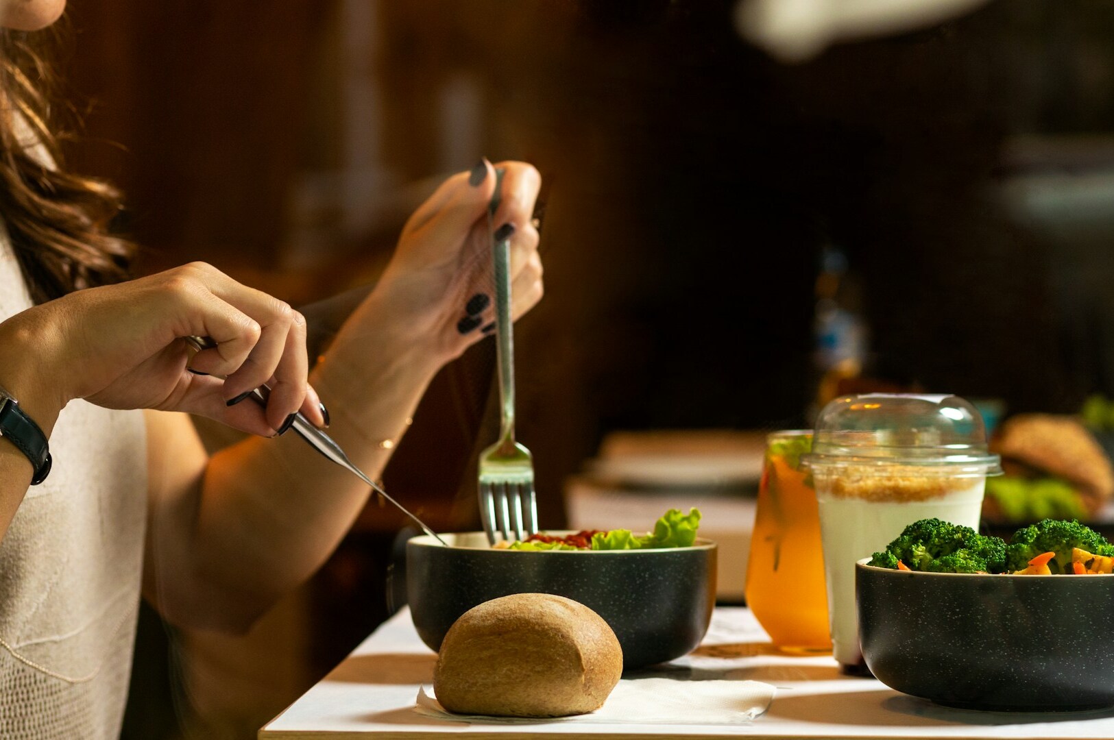 A woman eating a nutritious bowl of food with a fork, promoting healthy eating habits.