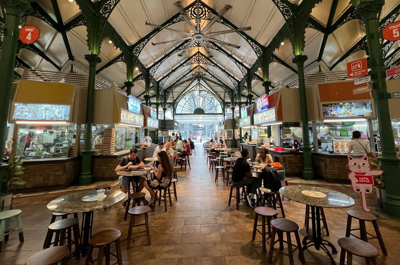 A bustling food court at the old town market, featuring various Singapore hawker stalls and diverse food options.