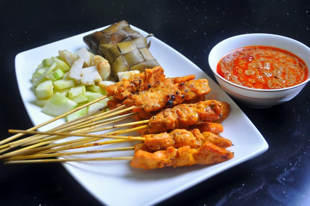 A plate of satay skewers featuring grilled meat and vegetables, arranged on a table.