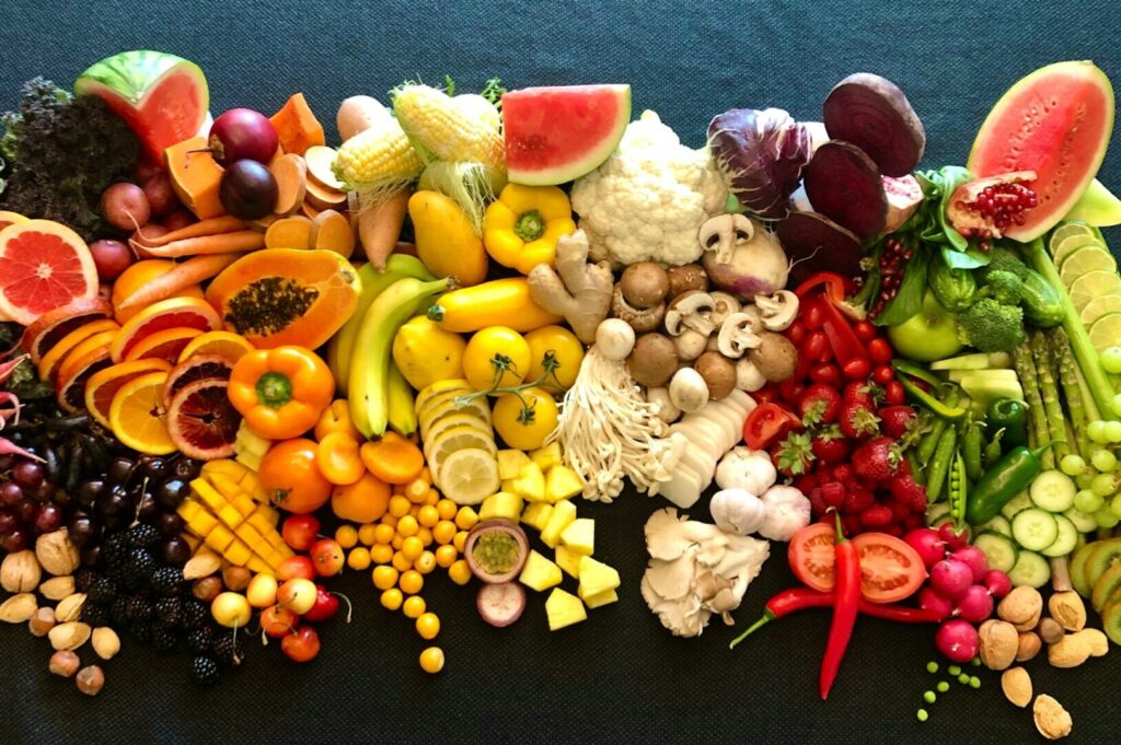 A colorful row of fruits and vegetables showcasing a variety of colors, emphasizing the importance of dietary fiber.