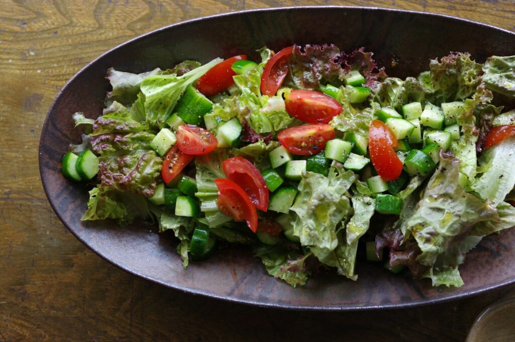 A vibrant bowl of salad with tomatoes, cucumbers, and lettuce, showcasing healthy antioxidant food options.