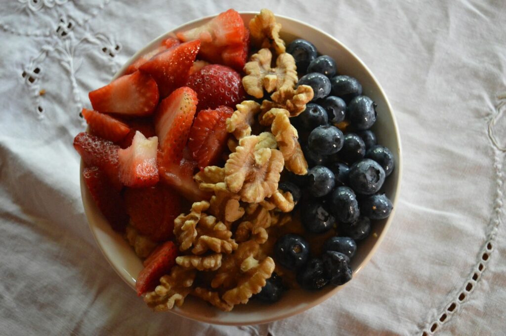 A colorful bowl of fresh fruits and mixed nuts, showcasing their antioxidant benefits for nutritious snacking.