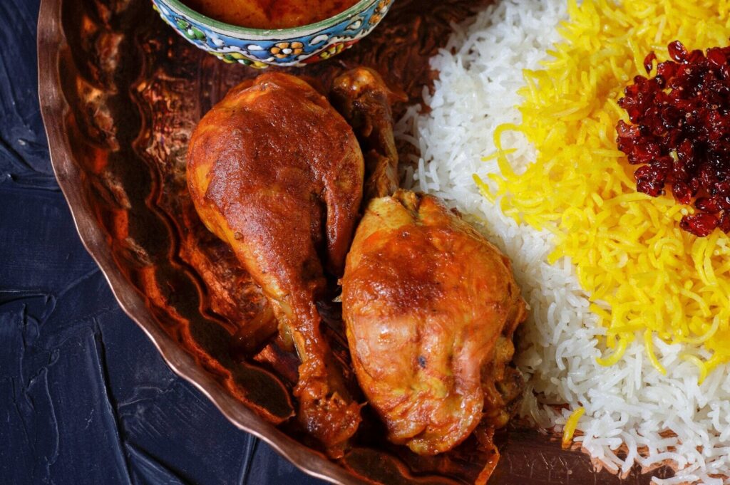 A plate of roasted chicken accompanied by rice, representing traditional cuisine.