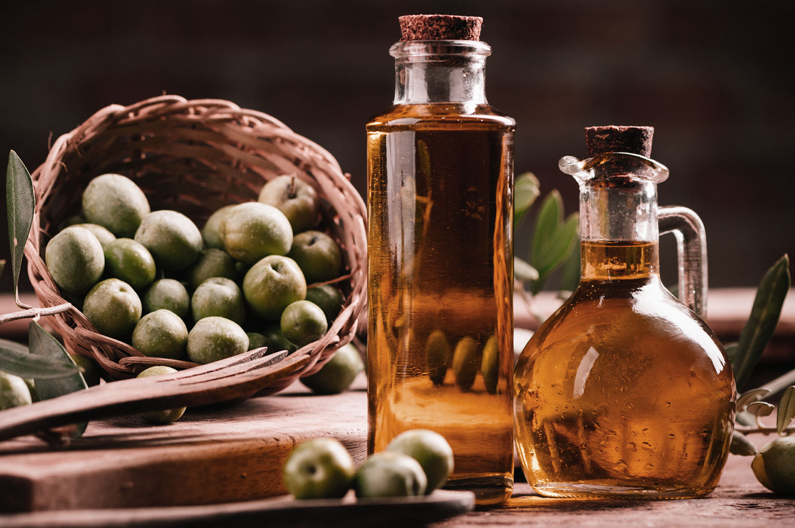 Virgin oil with olives and wooden cutlery on table