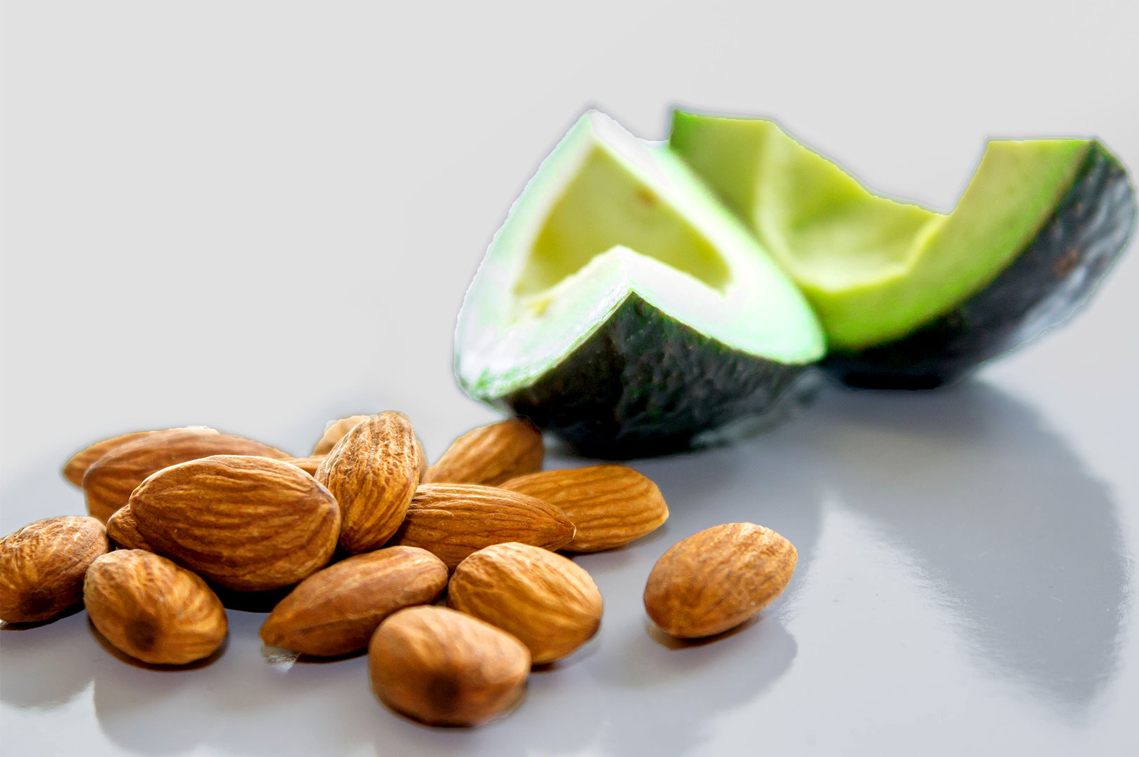Avocado and almond nuts on a white countertop