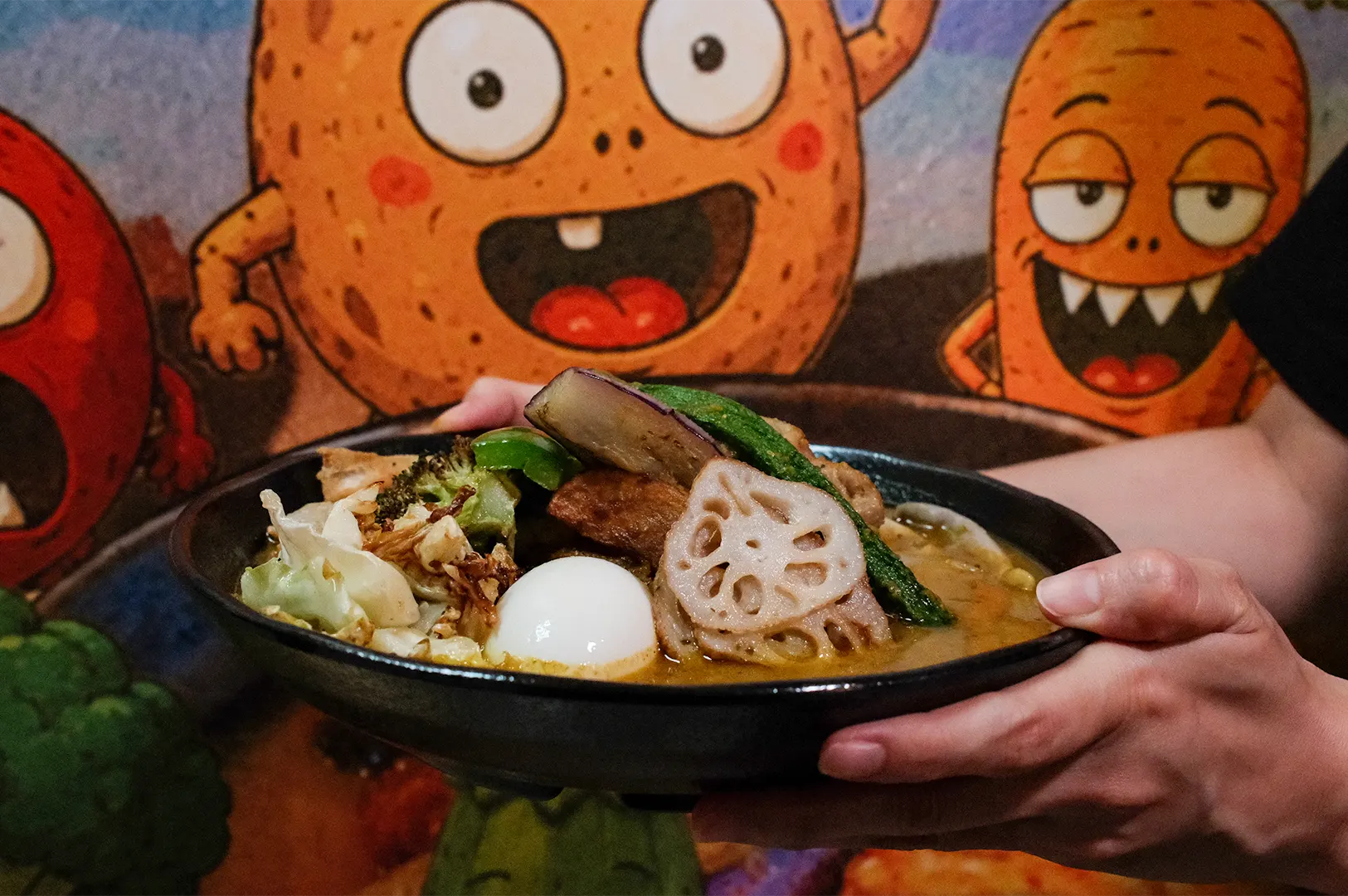 Bowl of Hokkaido soup curry with fresh vegetables and egg served at Soup Curry by Ki Setsu in Singapore.
