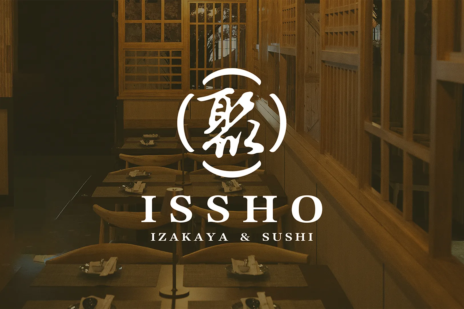 Warm-lit interior of a Japanese restaurant, featuring wooden decor and neatly set tables. Overlay text reads "ISSHO Izakaya & Sushi" with a Japanese character.