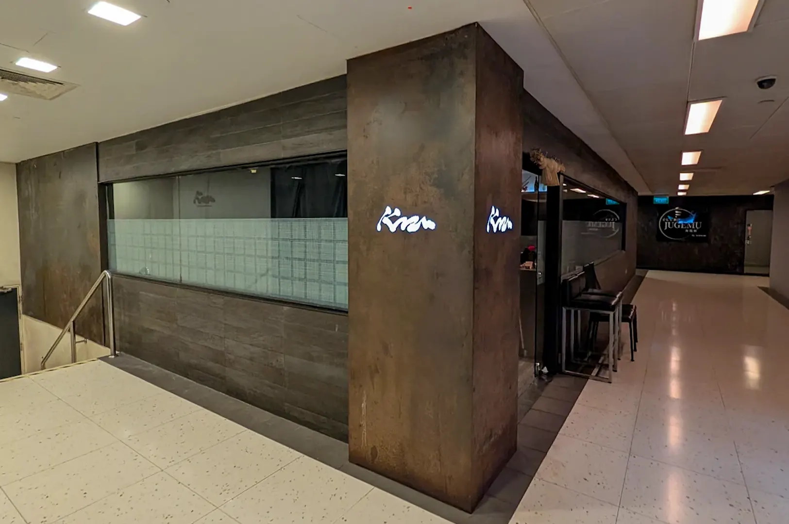 Kazu Sumiyaki Restaurant storefront with a dark wood and rusted metal pillar entrance in a mall corridor.
