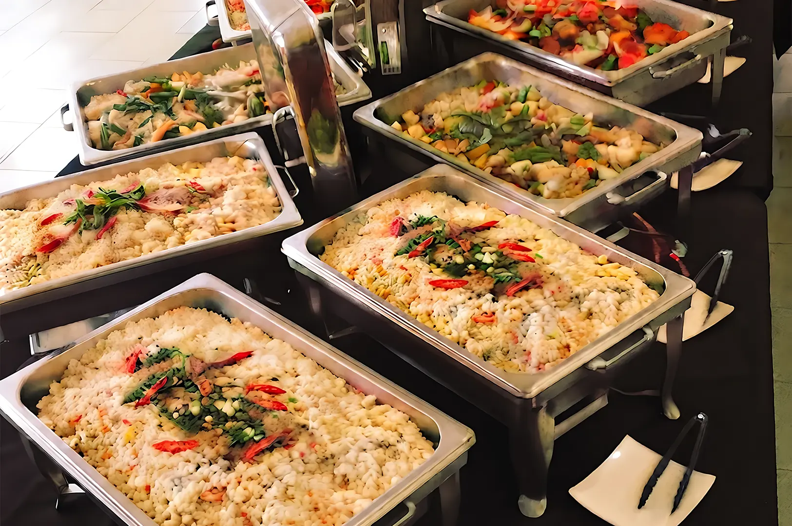 FattyDaddyFattyMummy catering buffet featuring a variety of Tingkat-style rice and vegetable dishes in chafing trays.