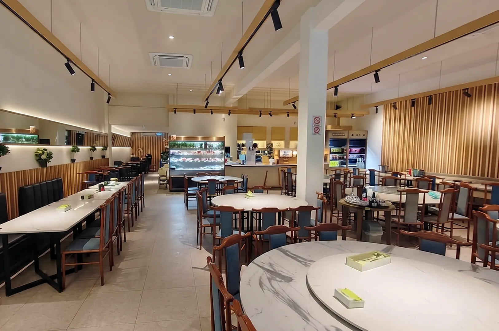 Interior dining area of Green on Earth Vegetarian Cafe at Rail Mall with round and long tables.