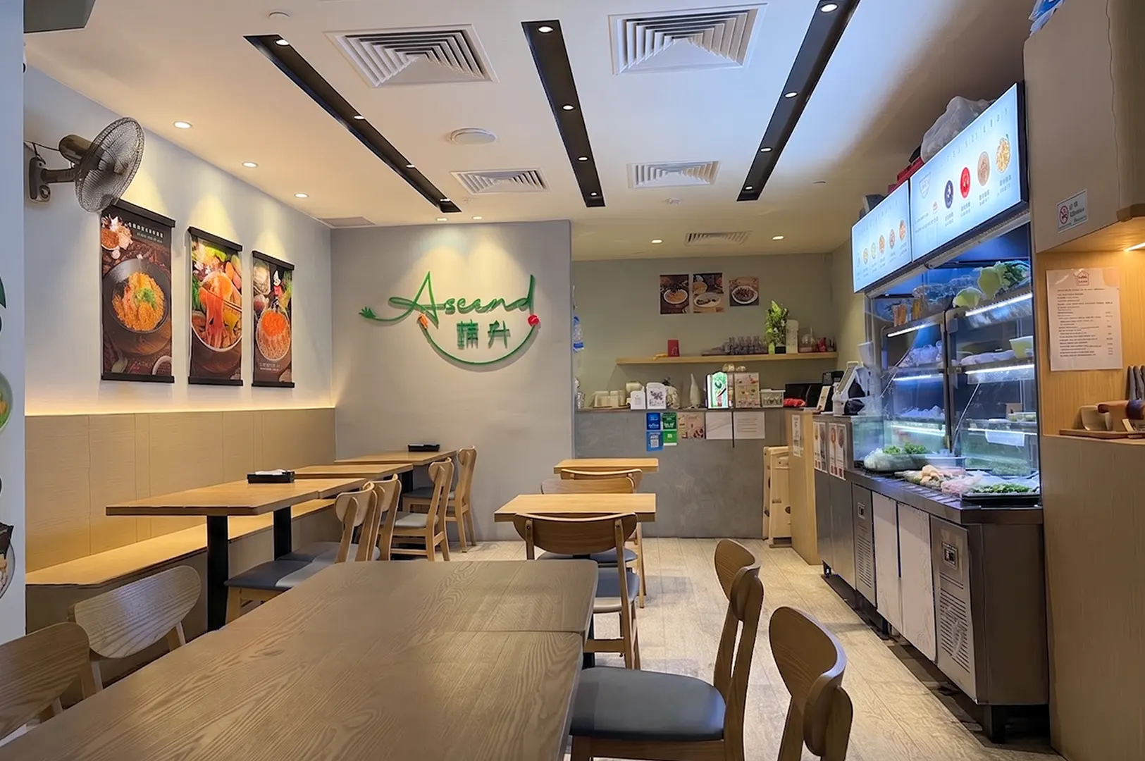 Interior view of the Ascend restaurant featuring wooden dining tables, seating, and a food counter.