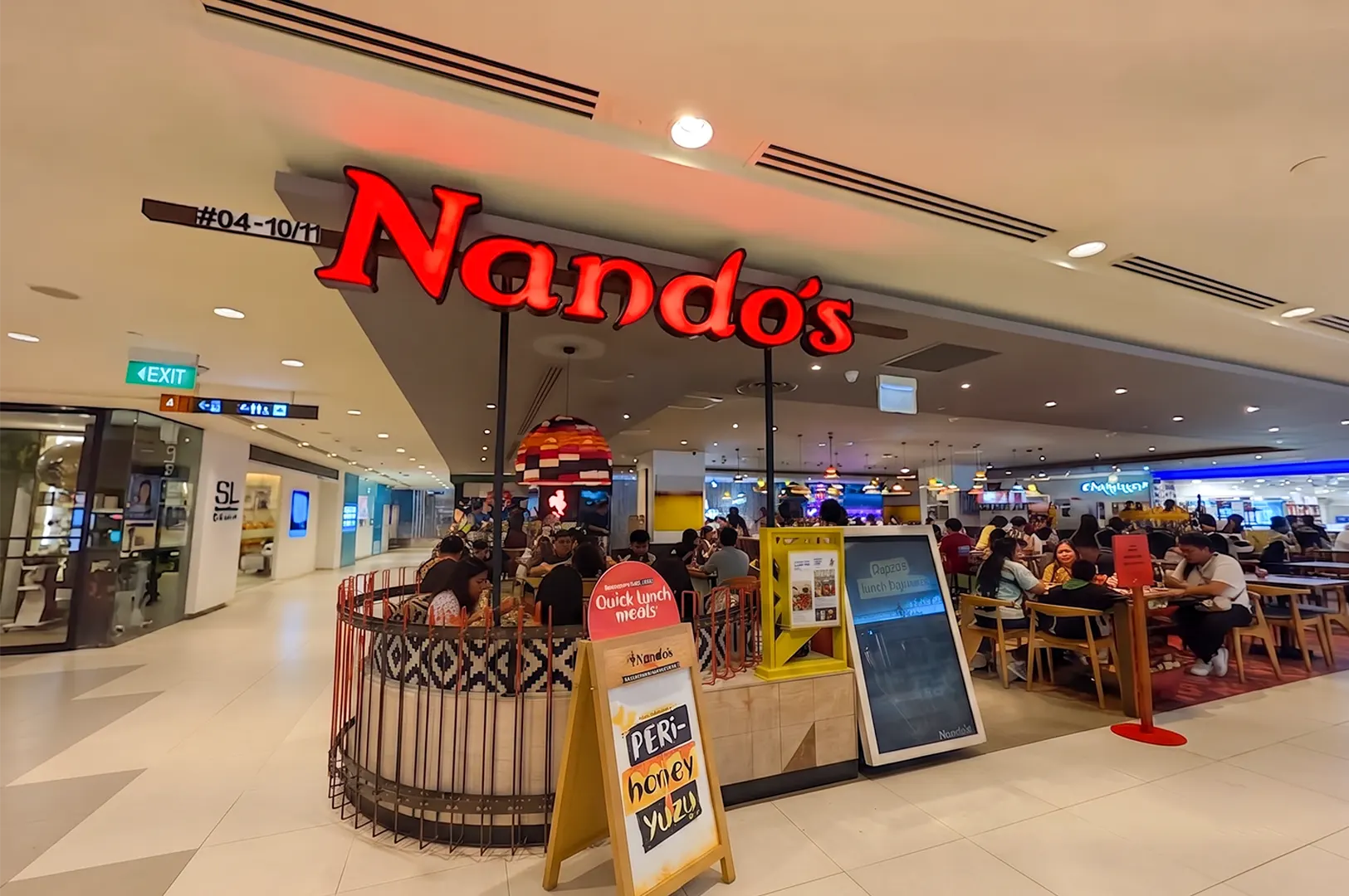 Nando's restaurant storefront and dining area inside a shopping mall.
