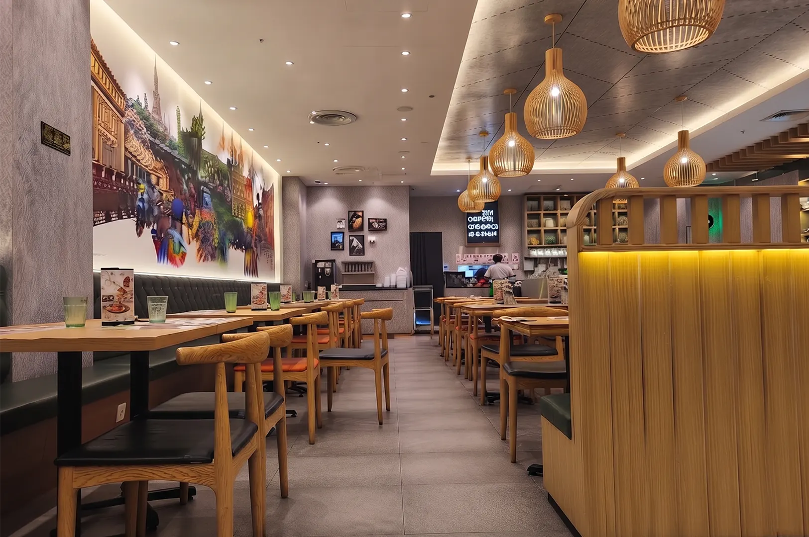 Sanook Kitchen interior dining area at Suntec City featuring wooden tables, modern pendant lighting, and a large mural wall.