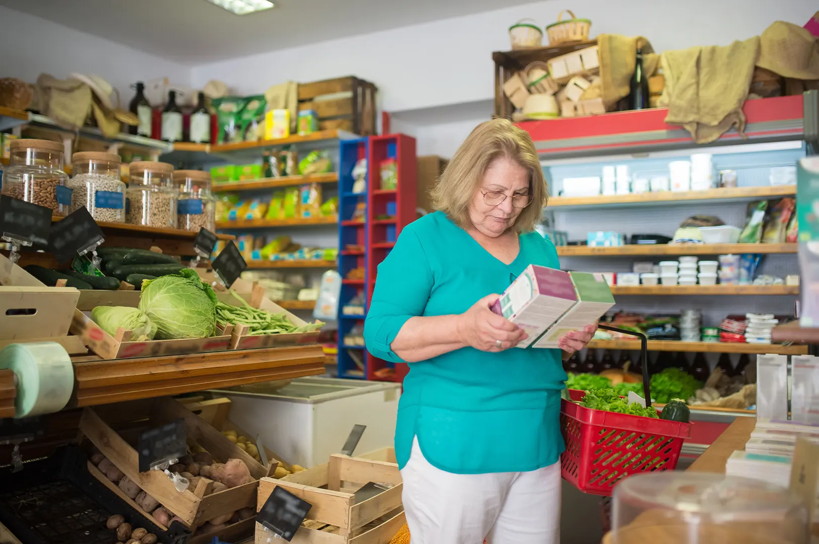 Shopper checking food product labels in a supermarket aisle.