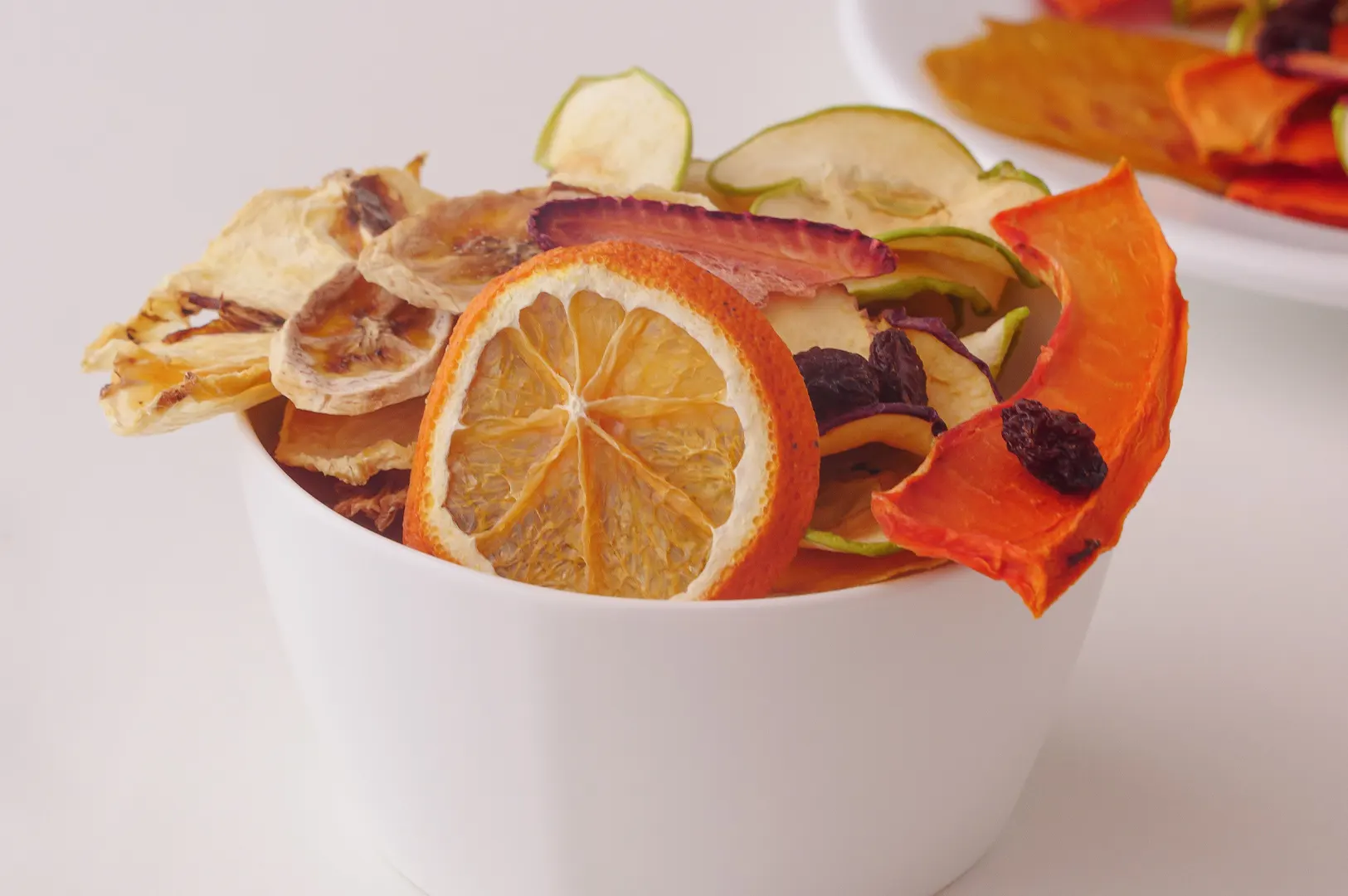 Assorted dried fruit snacks in a white bowl.