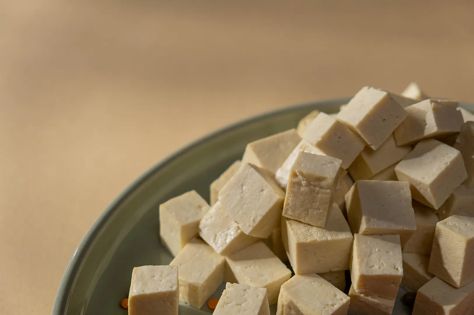 Fresh diced tofu cubes on a plate for a plant-based diet protein source.