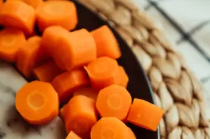 Fresh sliced carrots on a plate ready for cooking.