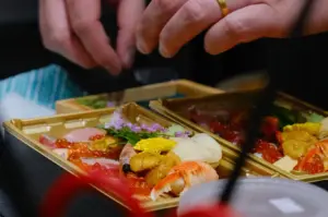 Fresh sashimi platter arranged in trays with uni and fish roe.