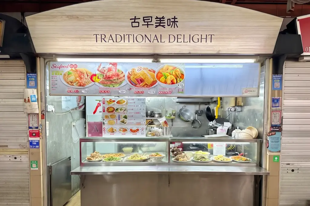 Traditional Delight hawker food stall front with a glass display counter and menu pictures of seafood dishes.