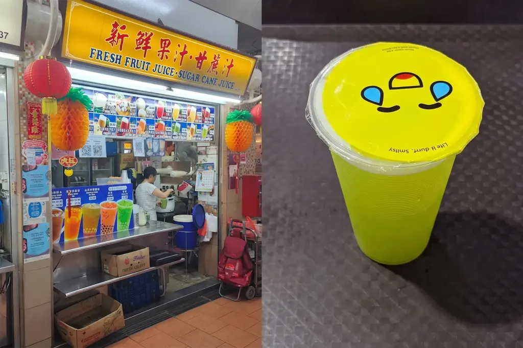 Fresh fruit and sugar cane juice stall menu next to a sealed cup of green sugar cane juice.
