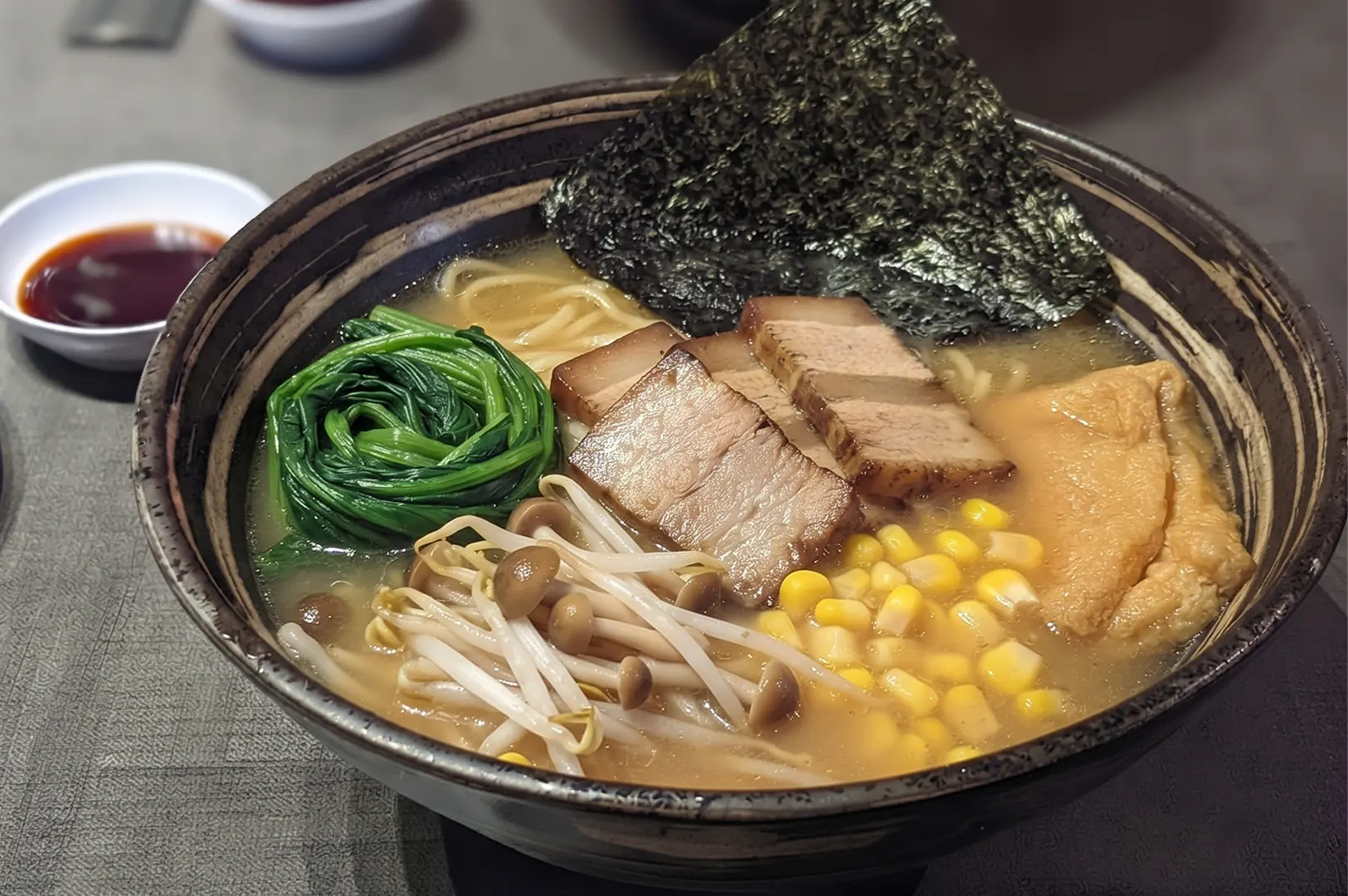 Vegan ramen bowl with noodles, greens, corn, and mock meat at Herbivore Fortune Centre.