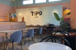 Interior view of Tipo Pasta Bar showcasing turquoise walls and cozy dining tables.