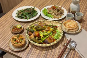 A spread of signature dishes at Zi Zi Vegetarian Tampines featuring crispy prata, golden yam ring, and other comforting vegetarian favorites.