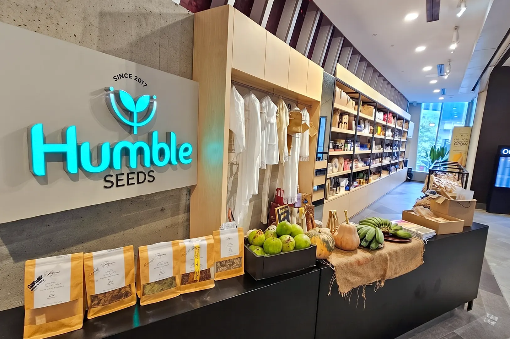 Inside the Humble Seeds organic store with product shelves, fresh produce display, and 'Since 2017' logo sign.