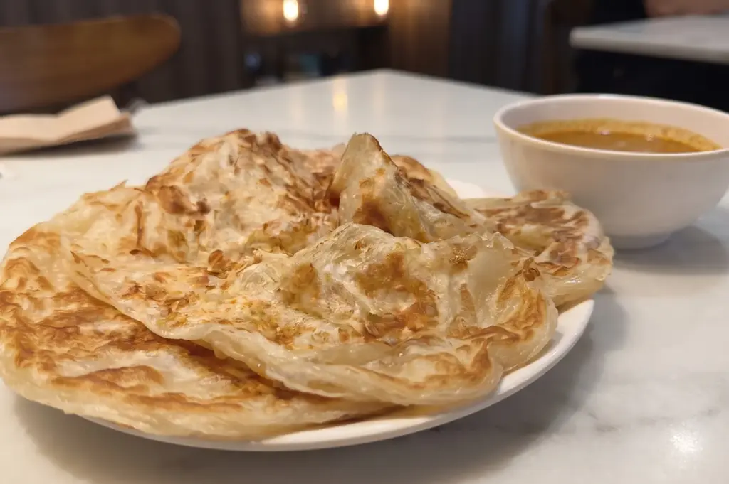Crispy plain prata served with a bowl of curry at Zi Zai Eating House.