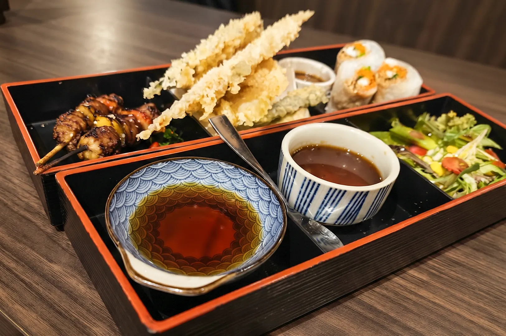 Japanese bento box set with tempura and side dishes.